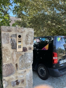 Visiophone Doorbird installé sur un pilier en pierre à l'entrée d'une propriété